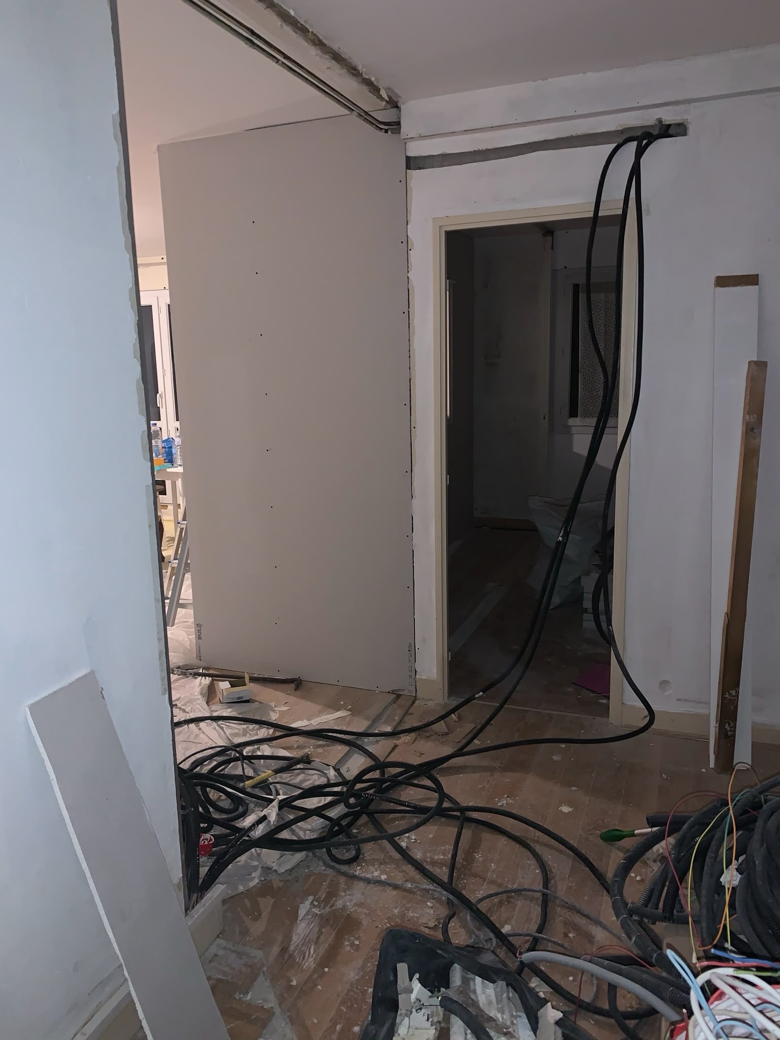 Passage de gaines électriques dans une cloison en cours de réalisation
