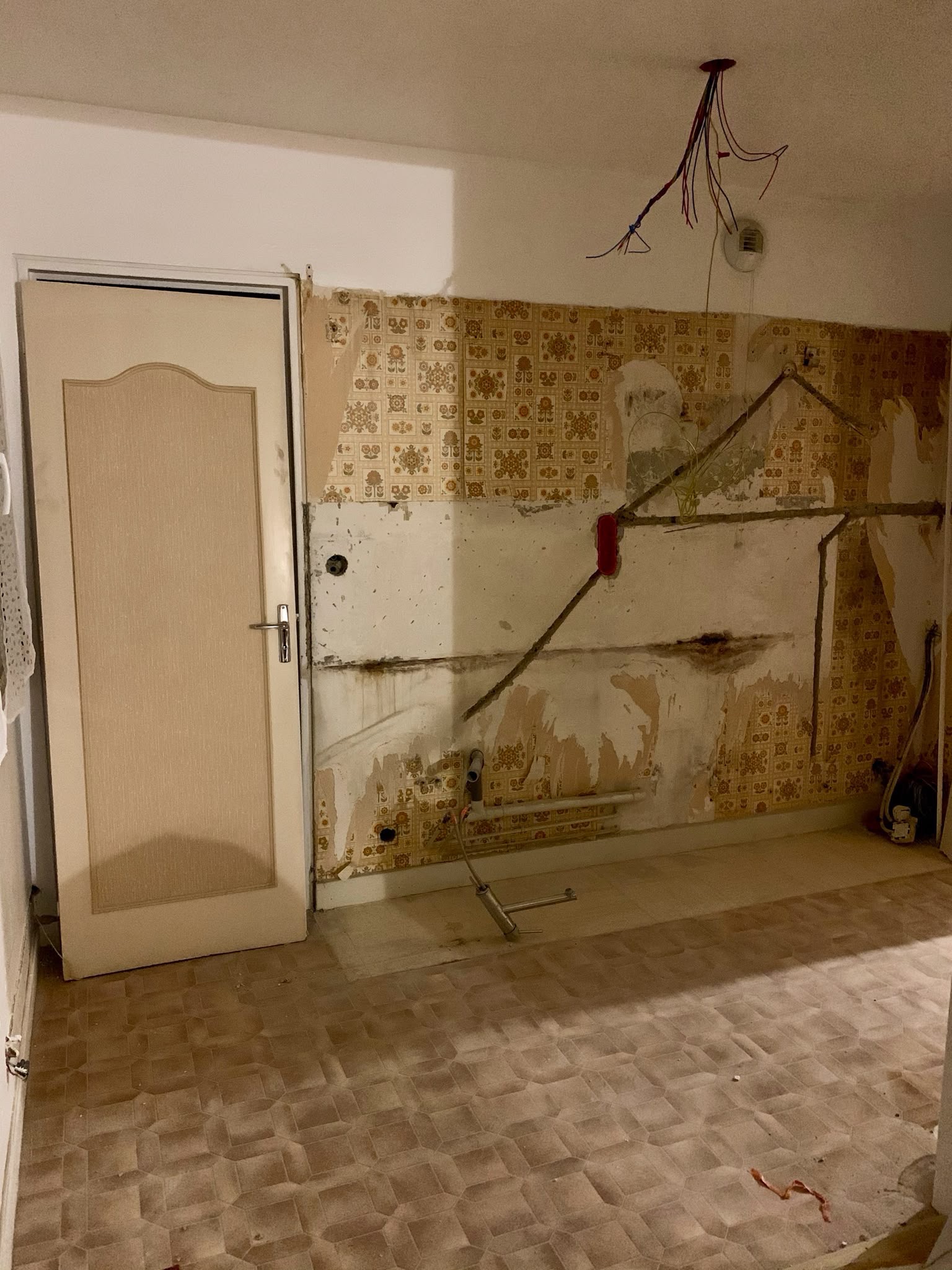 Mur de cuisine en rénovation avec câbles en attente