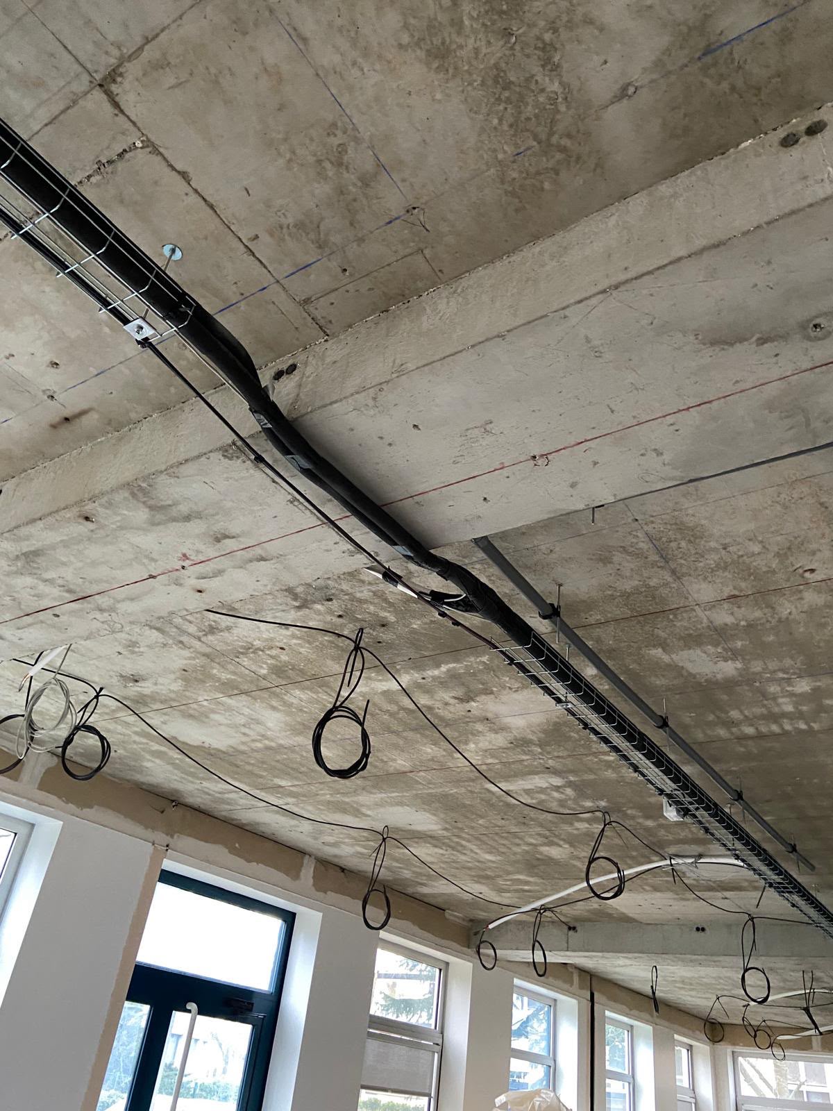 Chemin de câbles fixé sous un plafond en béton