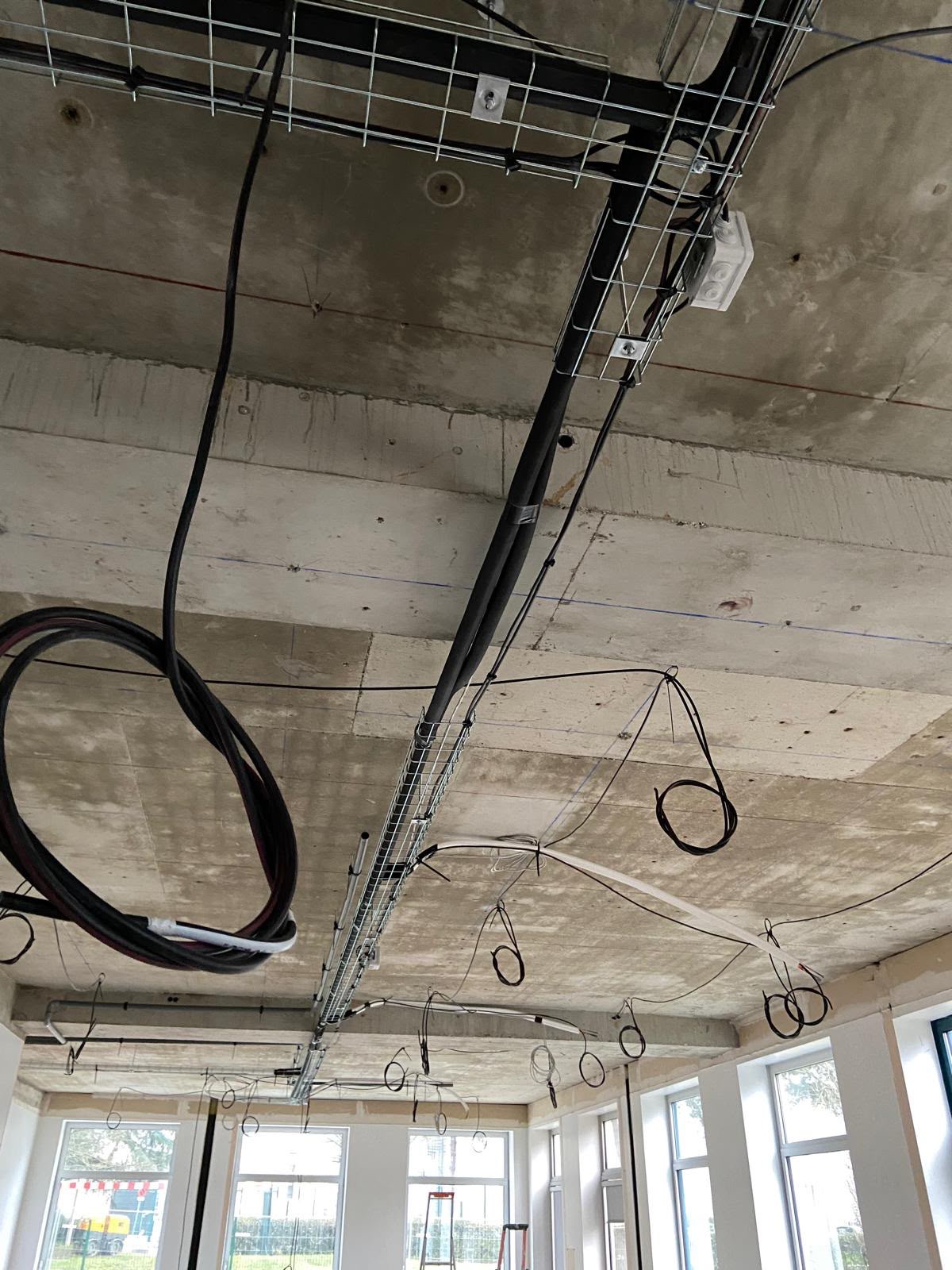 Chemin de câbles et réseaux électriques en cours d’installation au plafond